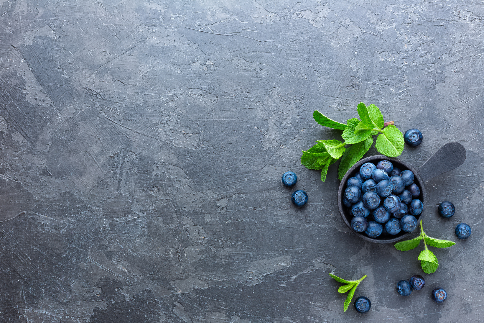 Fresh Blueberries in a bowl on dark background, top view. Juicy wild forest berries, bilberries. Healthy eating or nutrition.